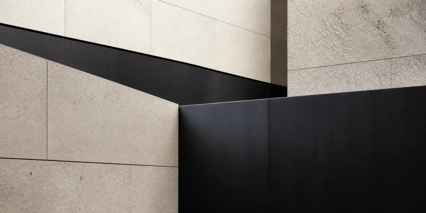 Interlocking limestone and dark steel planes arranged in a precise architectural grid